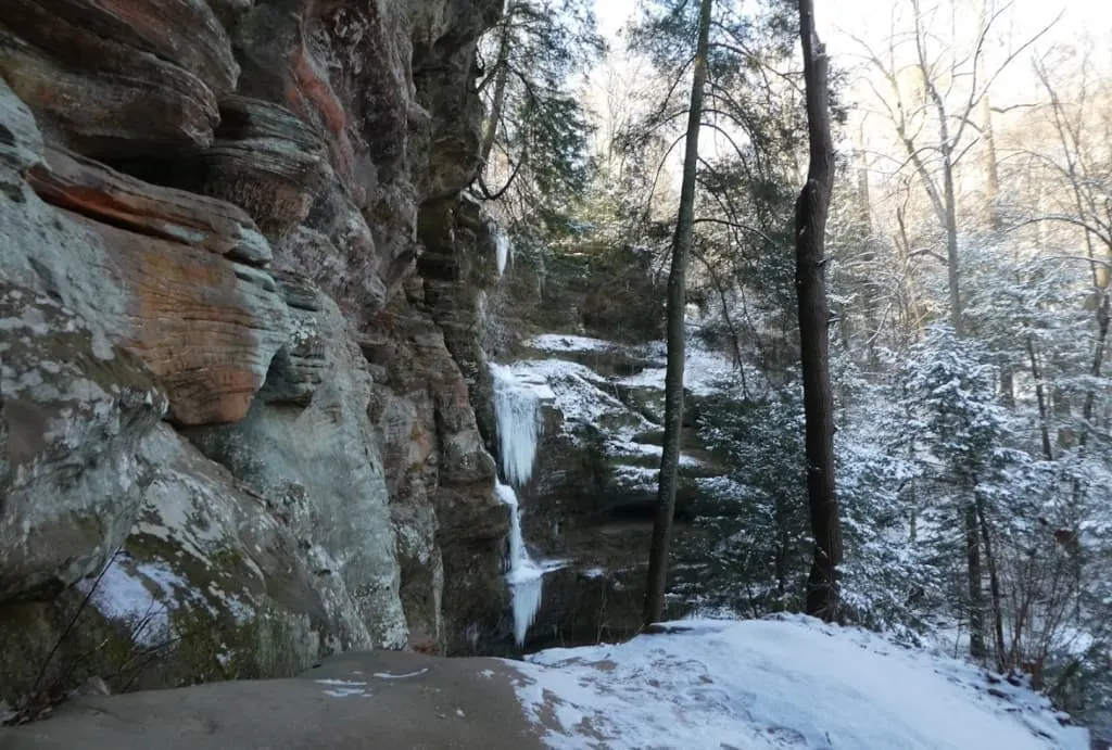 Snow-covered trail through a park.